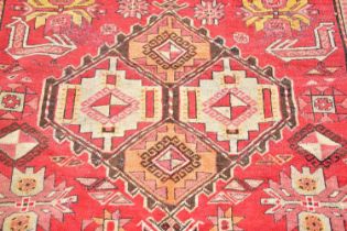 A red ground rug in the Bokhara style with stylised decoration and a further red and ivory ground