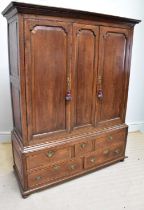 A George III oak livery cupboard, with two panelled doors enclosing hanging rail, above five