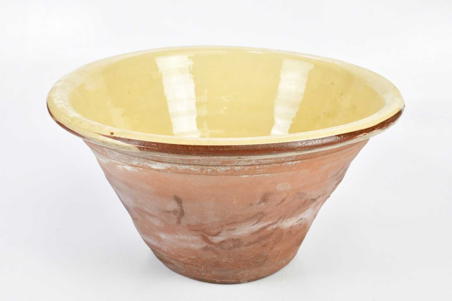 A large slipware terracotta dairy bowl, height 22cm.