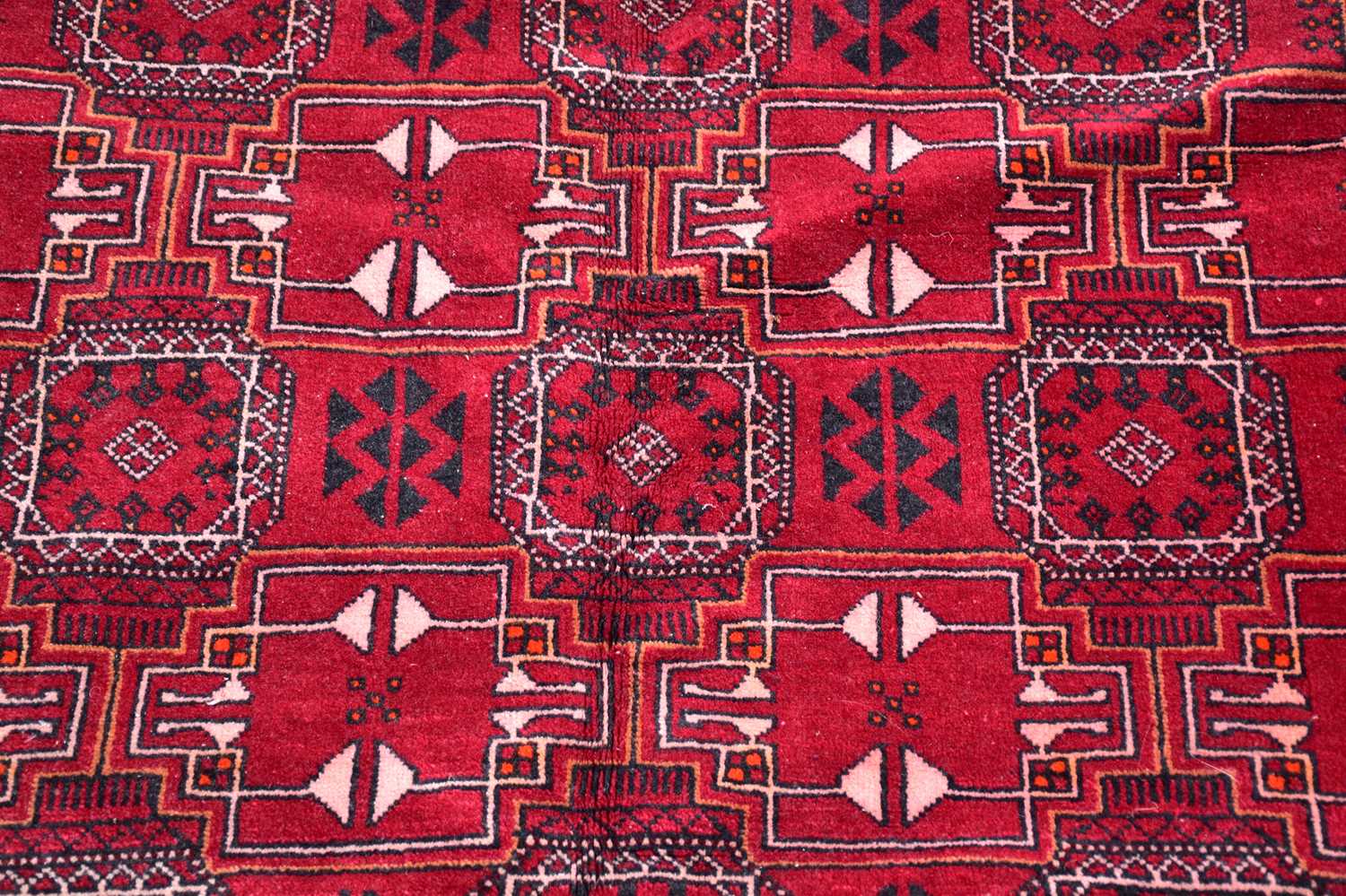 A red ground rug in the Bokhara style with stylised decoration and a further red and ivory ground - Image 2 of 4