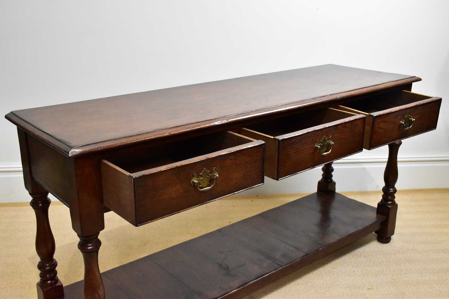 A 20th century three drawer oak dresser base, height 72cm, width 150cm, depth 46cm. - Image 2 of 3