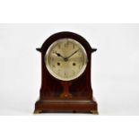 An Edwardian inlaid mahogany arch topped mantel clock, the circular dial set with Arabic numerals,