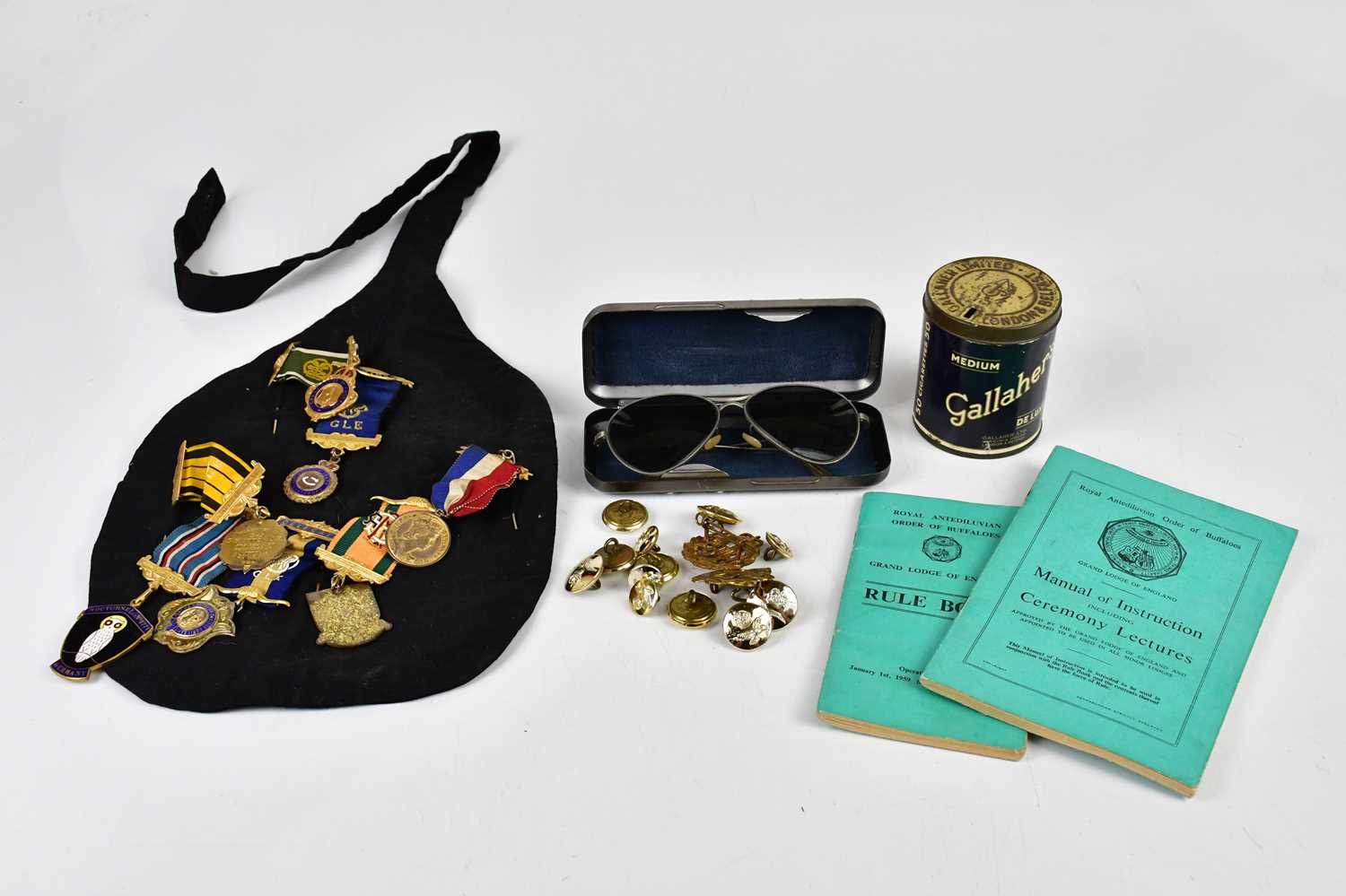 A collection of assorted Buffalo medals, military cap badges including RAF, British military glasses