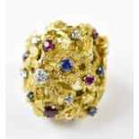 A huge 18ct gold chunky ring set with a multitude of gems including diamonds, rubies and