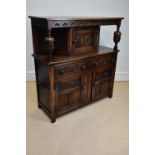 A reproduction oak court cupboard, with single panelled door above an arrangement of two drawers and