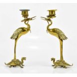 A pair of of early 20th century Japanese bronze figural candlesticks modelled as cranes, standing on