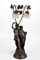 A modern bronzed figural table lamp with two frosted floral glass shades above a young couple,