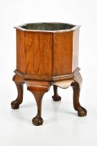 A late 19th century octagonal oak cellarette with four cabriole supports to ball and claw feet, with