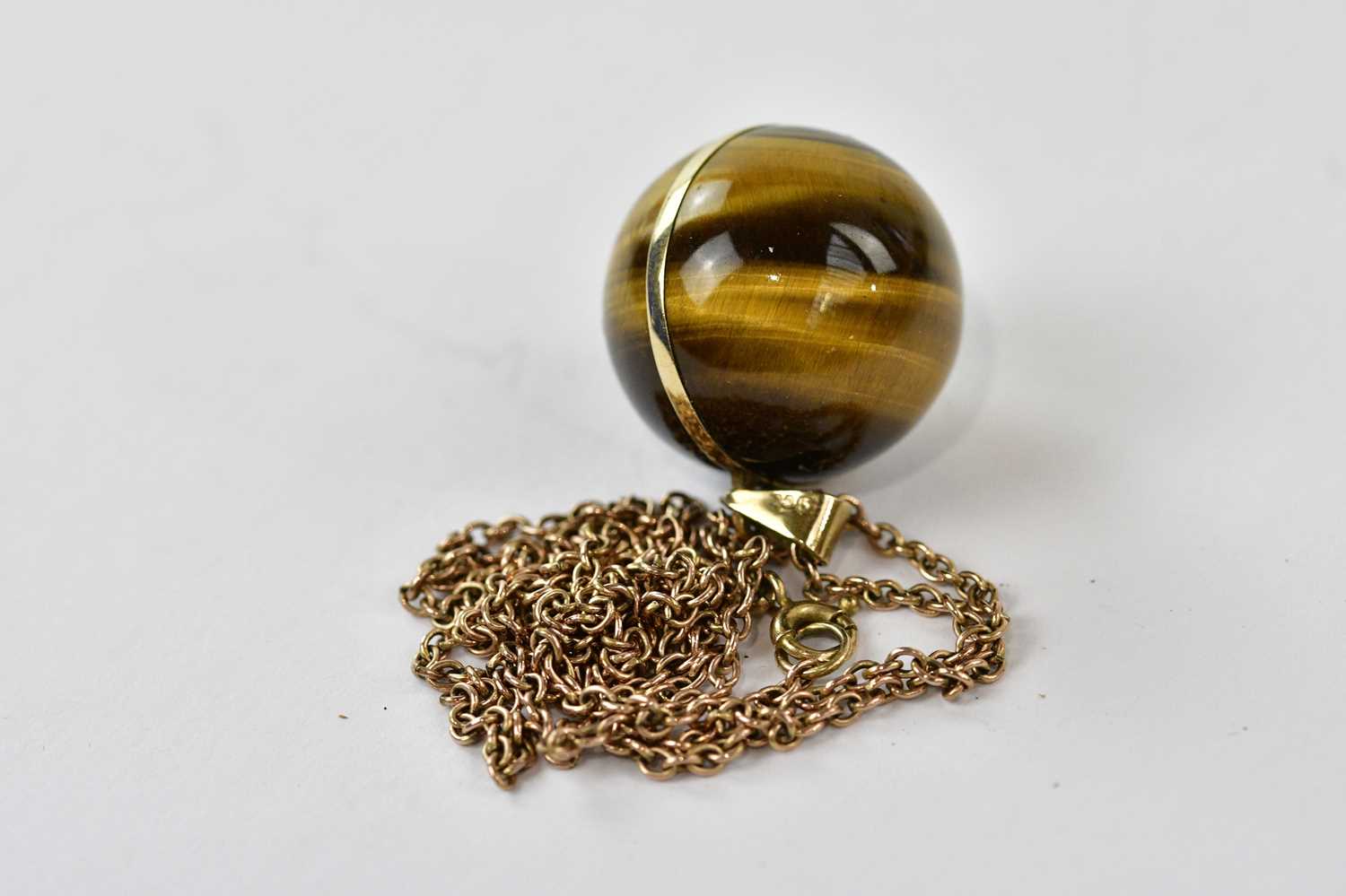 A yellow metal mounted tiger's eye pendant stamped 375, suspended on a chain. - Image 2 of 2