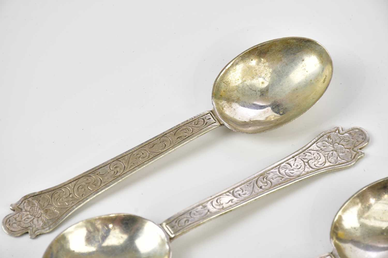 Five Continental white metal rat tail spoons, with chased scrolling decoration, indistinctly stamped - Image 2 of 6