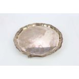 VINERS LTD; a George V hallmarked silver salver with cast scalloped edge, on three scrolling feet,