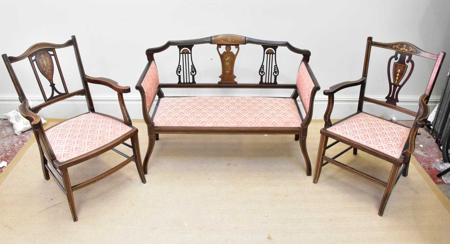 An Edwardian inlaid mahogany three piece salon suite comprising settee and two elbow chairs (3).