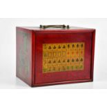 A modern Mahjong set in a red lacquered effect cabinet with four drawers.