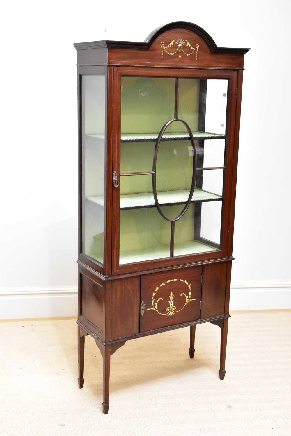 An Edwardian inlaid mahogany display cabinet with painted arched top and with a single glazed