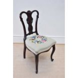 An Edwardian mahogany framed side chair, with carved open pierced back and floral woolwork seat.