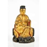 A 19th century Chinese gilt painted wooden model of Guanyin, with paper remains to the interior,