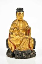 A 19th century Chinese gilt painted wooden model of Guanyin, with paper remains to the interior,