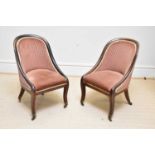 A pair of late Regency rosewood tub chairs with spoon backs, on sabre front supports and brass