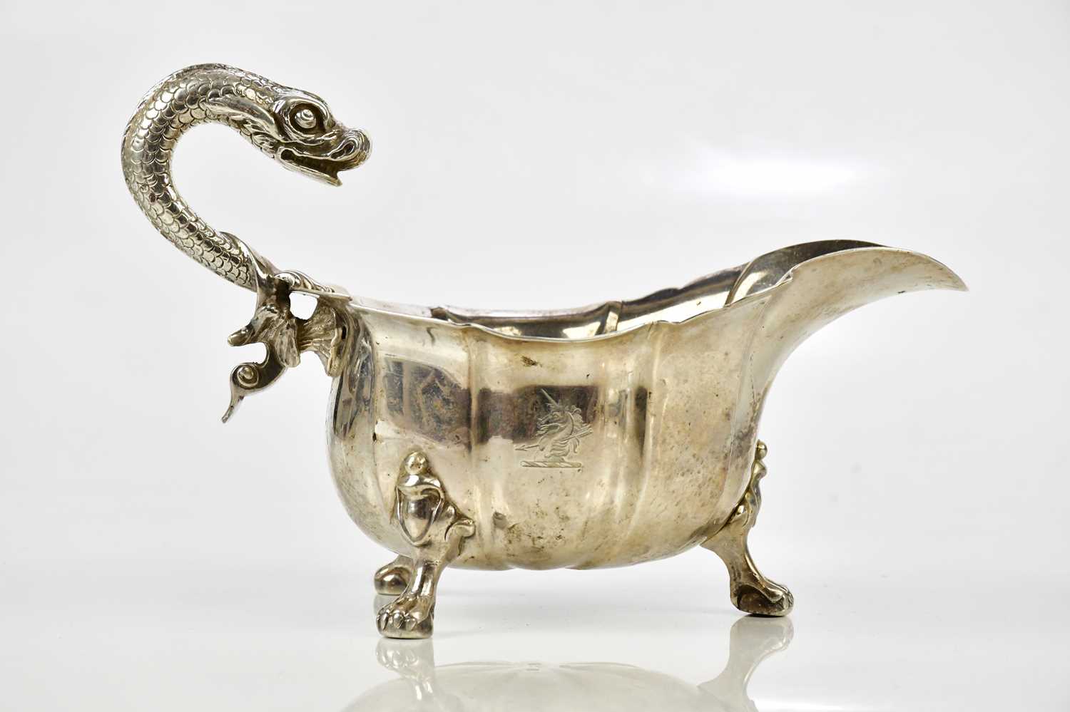 A good George III hallmarked silver sauceboat, with serpent handle and panelled body, on ball and