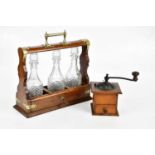 An early 20th century oak tantalus with silver plated mounts, housing three associated moulded glass