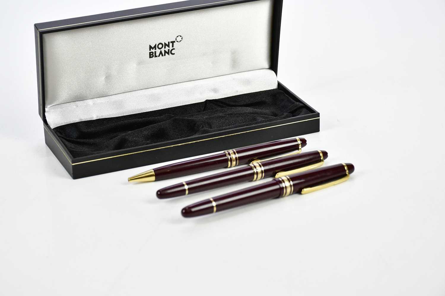 MONTBLANC; a set of three Meisterstuck burgundy pens including a cartridge fountain pen with 14K