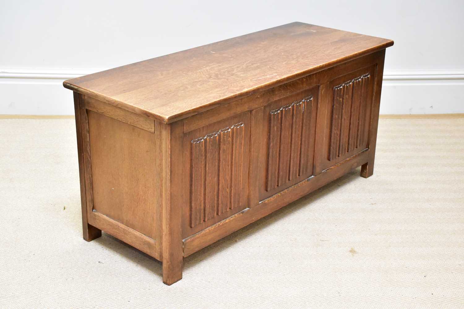 A 1950s oak blanket chest with linen fold decoration to the front, width 113cm, depth 43cm, height