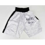 MIKE TYSON; a pair of signed white and black boxing shorts, inscribed 'Ali is the greatest, I am the