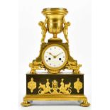 A late 19th century French ormolu mantel clock with cherubs supporting an urn finial above the