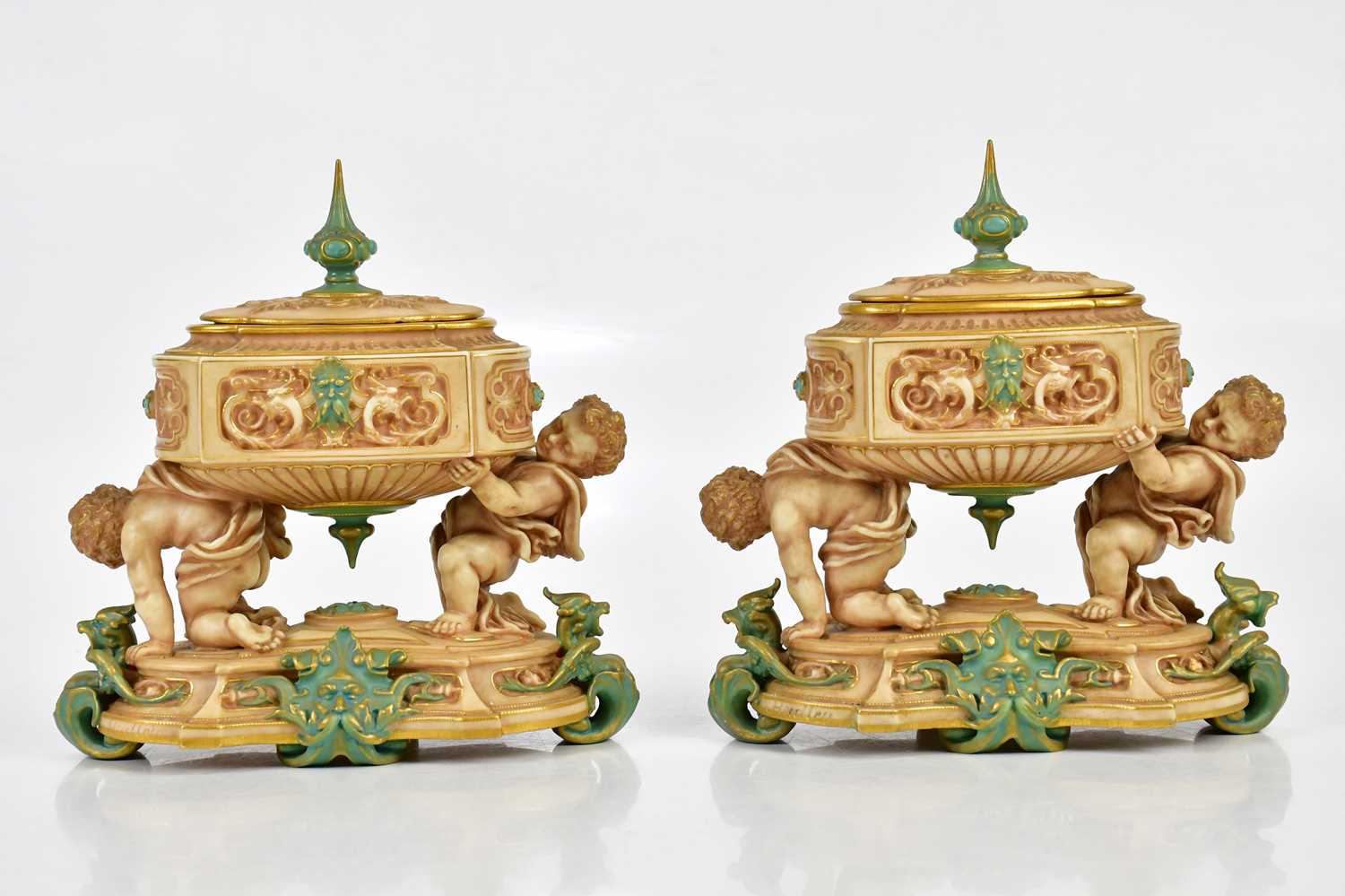 ROYAL WORCESTER; a pair of unusual lidded urn vases of oval form, the urns supported by cherubs on a - Image 4 of 6