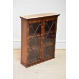 A reproduction mahogany display cabinet with two astragal glazed doors housing shelves, width