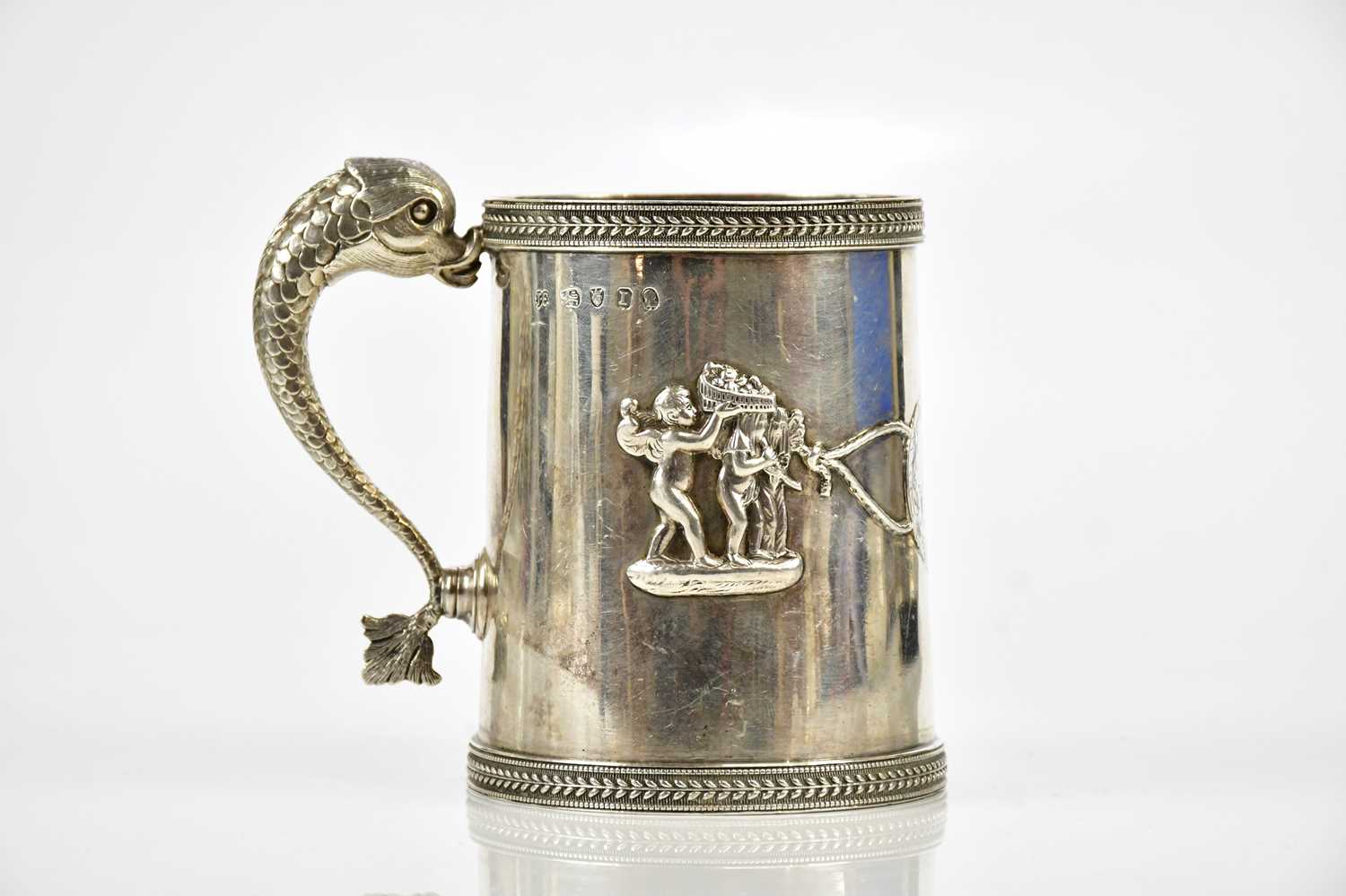 JOHN EMES; a George III hallmarked silver mug, with dolphin handle and cast borders within which