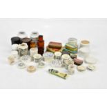 A collection of pharmaceutical related items including pot lids, ointment pot, black and white