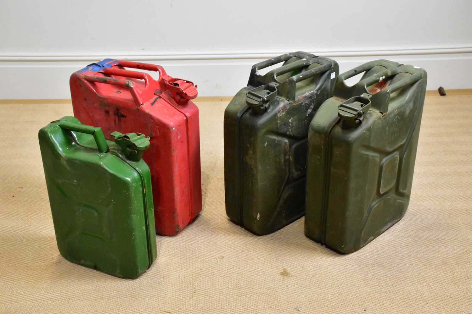 Four vintage metal jerry cans including a red example, largest approx 46cm.