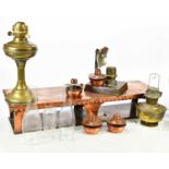 A copper warming plate stand with four burners, length 83cm, and a reflecting lamp and two brass oil