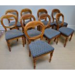 A set of nine Victorian balloon back dining chairs on turned column supports.