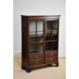 A mahogany display cabinet with two glazed doors above four drawers on bracket feet, width 102cm,