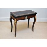 A 19th century ebonised and rosewood gilt metal mounted fold-over games table, with porcelain oval