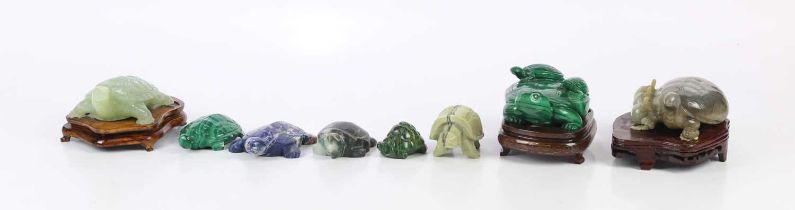 A collection of eight hardstone carved tortoises, including jade and malachite examples.