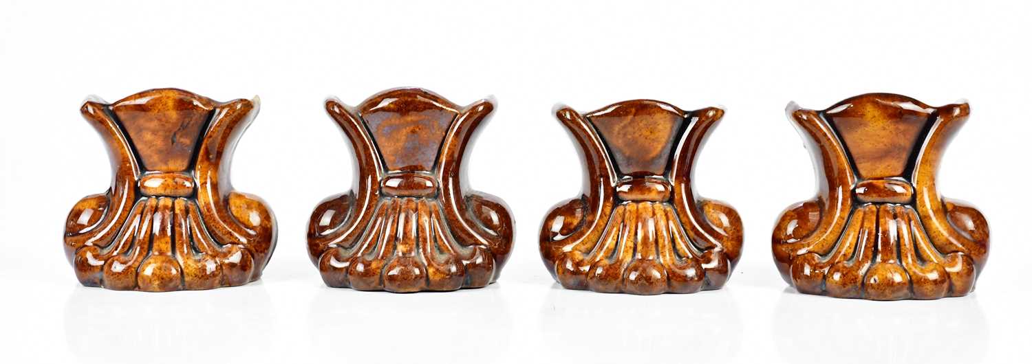 Two pairs of 19th century treacle glaze furniture rests modelled as scrolls, height 10.5cm (4).