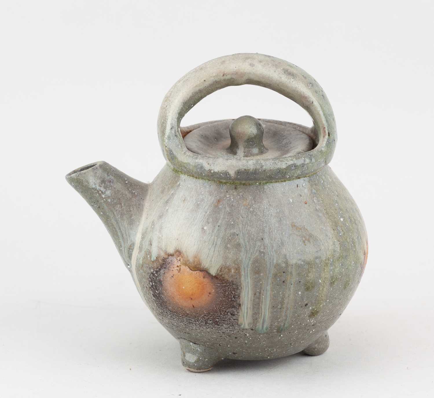 † SVEND BAYER (born 1946); a wood fired stoneware teapot on tripod feet partially covered in ash