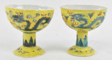 A pair of Chinese Republic period yellow ground Famille Rose stem cups, decorated with dragons,