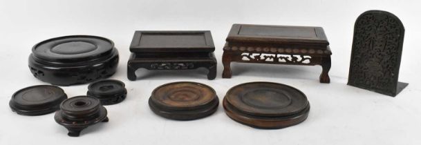 A group of eight Chinese carved hardwood display stands including two rectangular stands, the