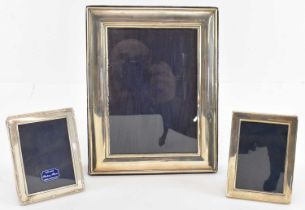 A group of three hallmarked silver photograph frames, largest 22.5cm x 17.5cm, the others both 10.