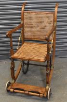 An early 20th century cane seated invalid's chair.