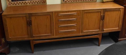 A mid century teak sideboard with four central drawers and two pairs of cupboard doors, width 212.