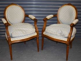 A pair of reproduction French style open arm elbow chairs, with upholstered backs and seats.