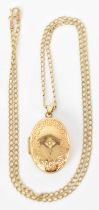 A 9ct yellow gold necklace suspending a 9ct yellow gold locket set with small central stone,