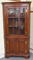 A reproduction Georgian style freestanding corner cupboard, the glazed door above pair of cupboard