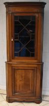 An Edwardian mahogany and crossbanded full length freestanding corner cupboard with glazed upper