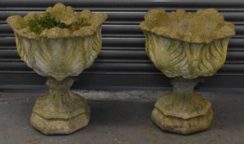 A pair of composite stone urns on stands, height approx 58cm.